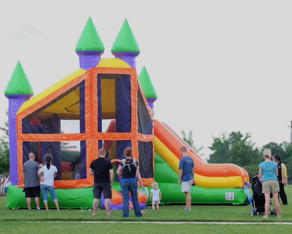 Colorful castle combo bounce house with slide set up outdoors for a Patriot Jumps rental in Acadiana, Louisiana