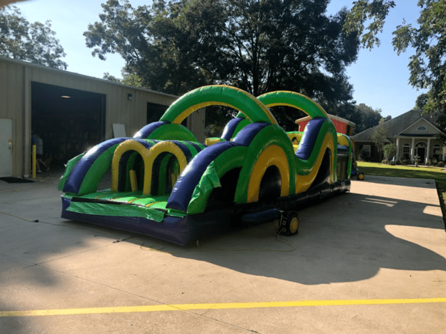 Side view of a green inflatable obstacle course rental for a church event
