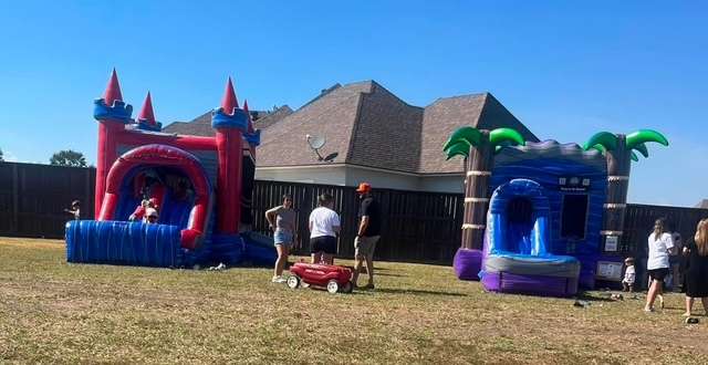 Kids playing at a pink castle combo bounce house rental for a school event