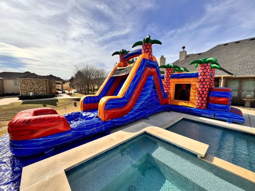 Red and blue inflatable water slide rental with splash pool beside a house