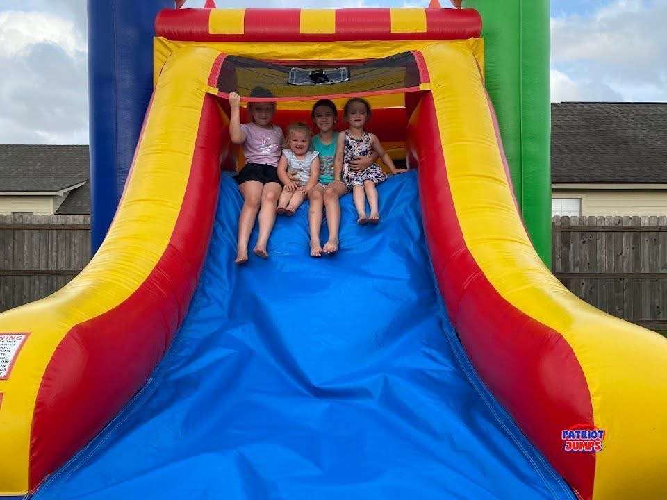 Kids sitting together on an inflatable slide at a family gathering in Acadiana Louisiana