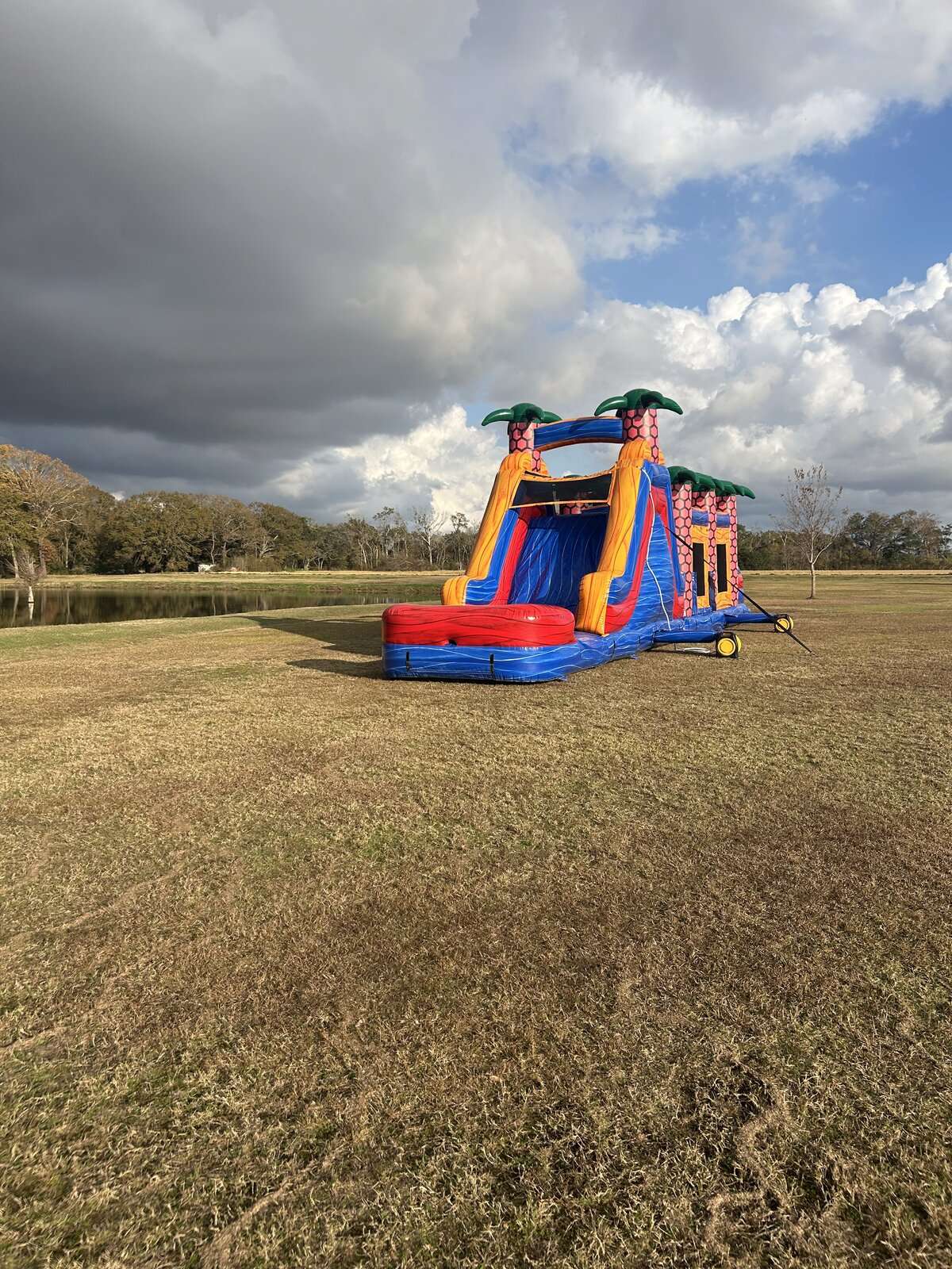 Bounce house and water slide combo rental in a field as storm clouds roll in near Maurice, Louisiana