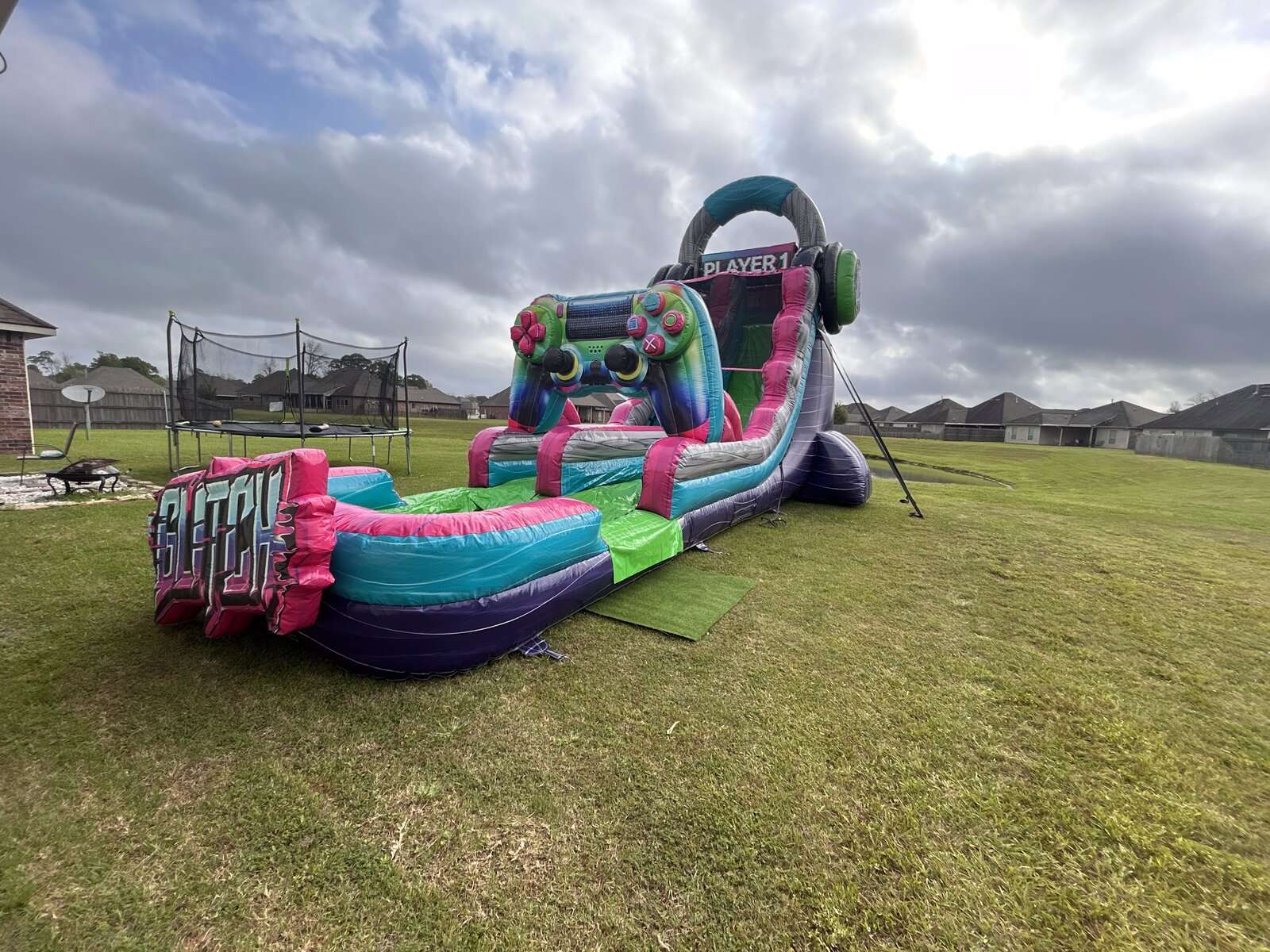 Glitch gamer-themed water slide rental set up on grass for a teen birthday party in Youngsville, Louisiana
