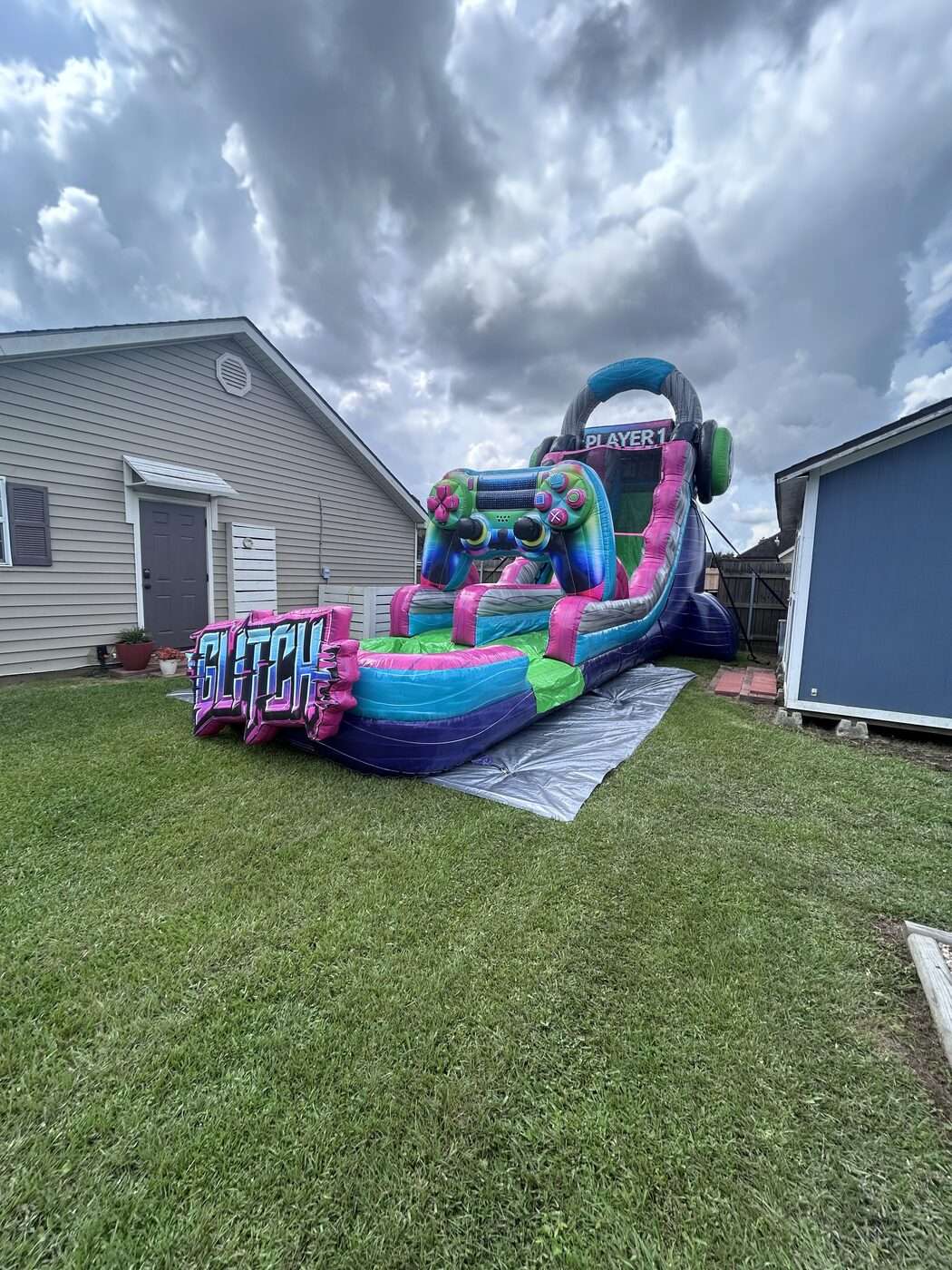 Glitch gamer-themed inflatable water slide rental set up in a Youngsville, LA backyard for a back-to-school party