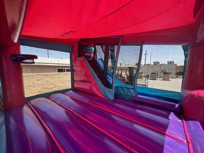 Interior view of a red and purple bounce house rental showing the mesh safety windows and clean jumping surface before an Acadiana party